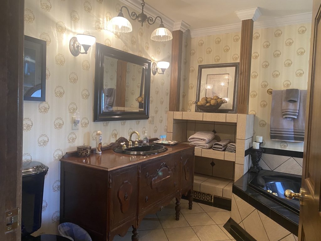 Antique sink cabinet, mirror and lights in the bathroom for Athena's Enchanted Room.