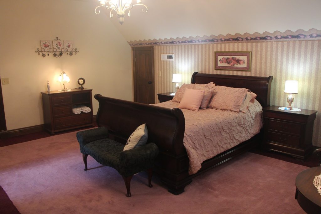 Guinevere's Rose Room. Bed, dresser, nightstands, lamps.